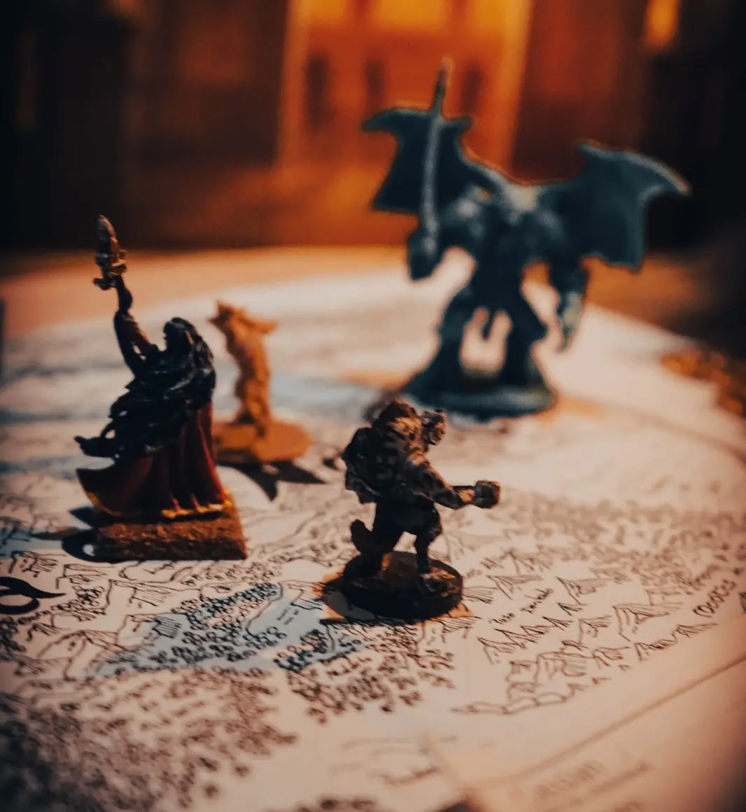 Figuras de místicos heroes y temibles demonios posando encima de un mapa de una región fantástica