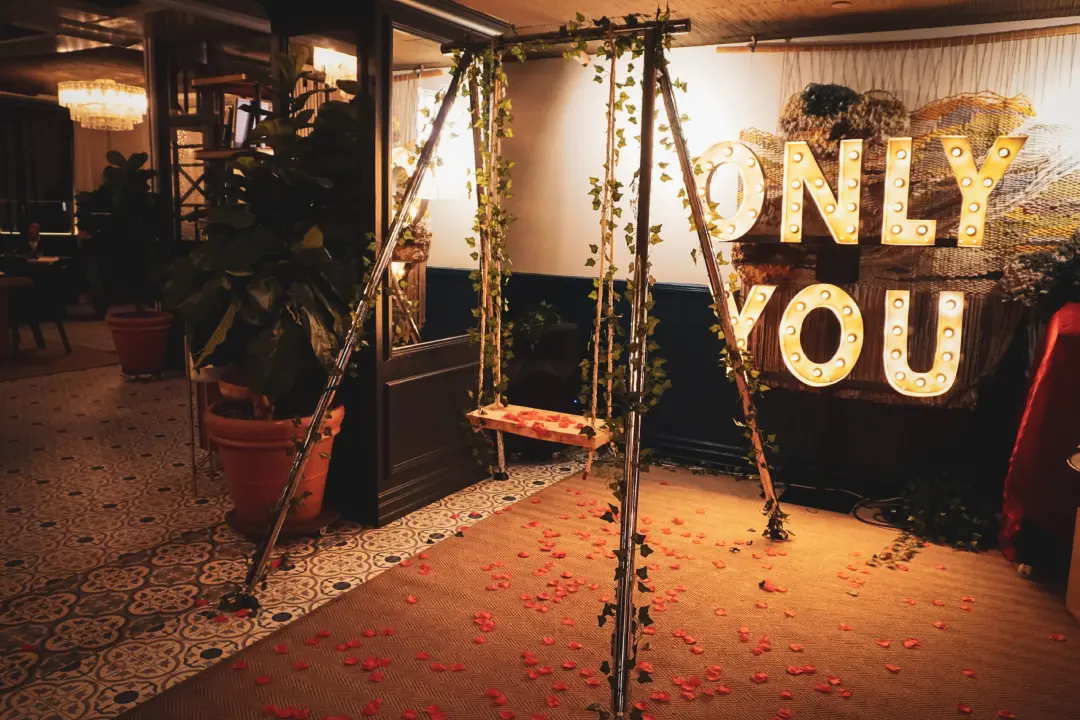 Precioso columpio rústico con petalos de rosa alrededor de él