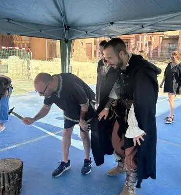 Persona medieval formando a un compañero para hacer una construcción de madera