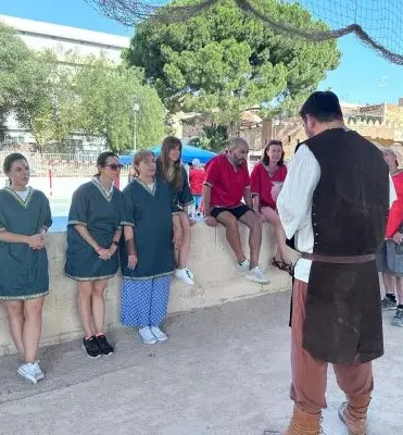Personas medievales escuchando el pregón de un mensajero